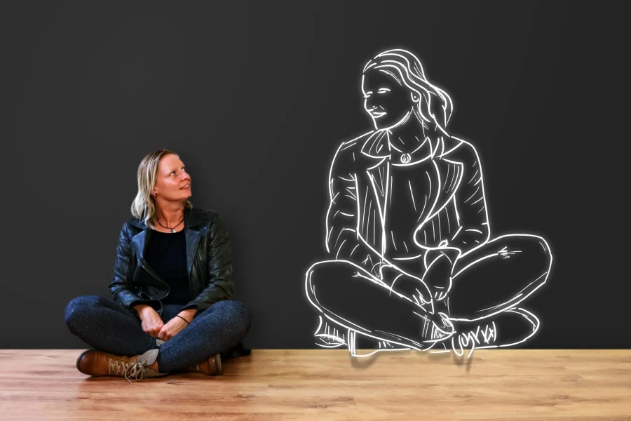 confiance en soi grâce à l'hypnose Femme assise regardant la projection d'elle-même souriante, lumineuse et comme grandie, symbolisant la confiance en soi et l'estime de soi retrouvées grâce à l'hypnose à Nantes avec Isabelle Guitard