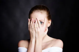 Femme se cachant le visage, illustration d'une seance d'hypnose pour vaincre les peurs et les phobies à Nantes.